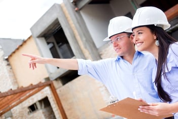 Civil engineers working in a construction site and pointing away
