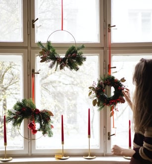 holiday wreaths hung on windows