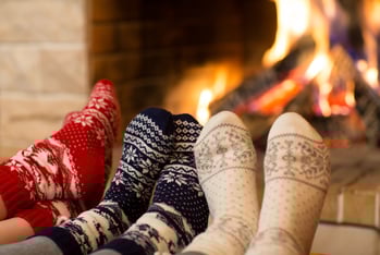 people wearing cozy socks and sitting around the fireplace