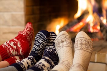people wearing cozy socks and sitting around the fireplace