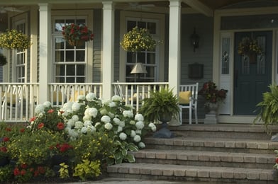 Glow of summer sunrise on front porch of suburban house