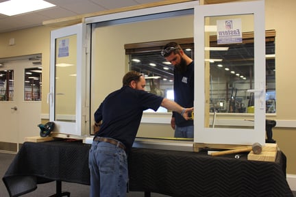 Door professionals installing model size door into frame