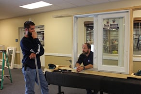 Door installers working on model size door and frame