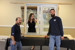 Door installers in front of model size door and frame