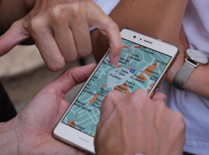 people pointing to location on mobile map