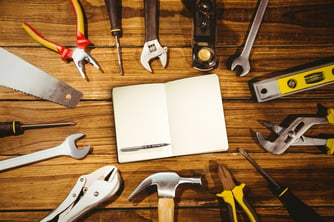 Notebook and pen against tools on desk