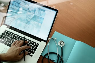 top view of Medicine doctor hand working with modern computer and smart phone on wooden desk as medical concept